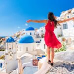 Woman standing in Greece with village in the background