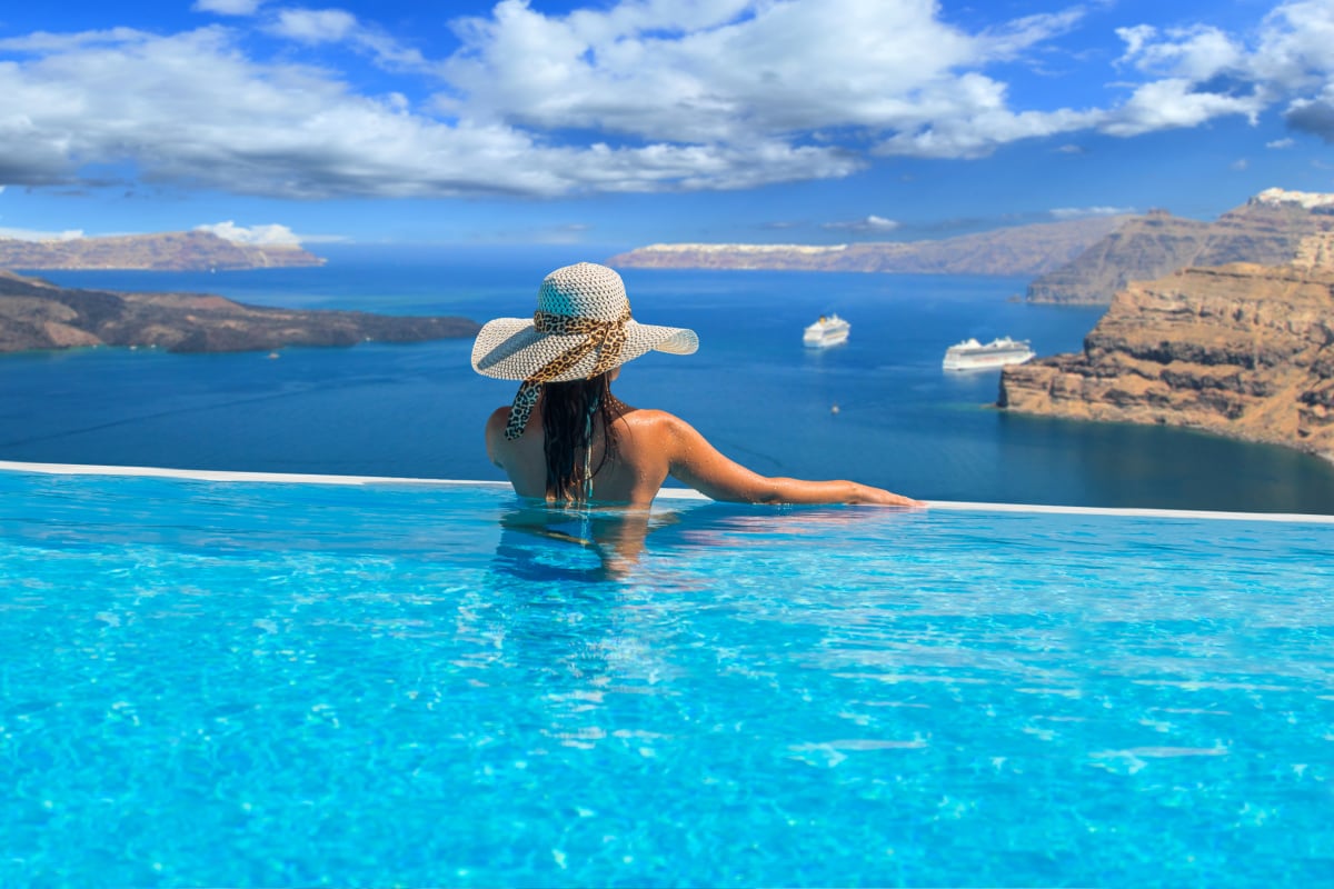 Woman in a pool looking at the view in Santorini Greece