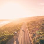 Aerial view of car on a road next to ocean