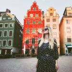 solo female traveler wandering around a colorful square in stockholm sweden