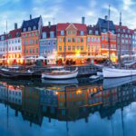 panorama shot of the nyhavn district of copenhagen with reflections of colorful buildings in the water