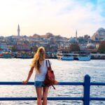Young Woman Admiring A View Of The Historical Peninsula Of Istanbul From Galata Bridge, Istanbul, Turkiye Or Turkey Western Asia, Eastern Europe.jpg