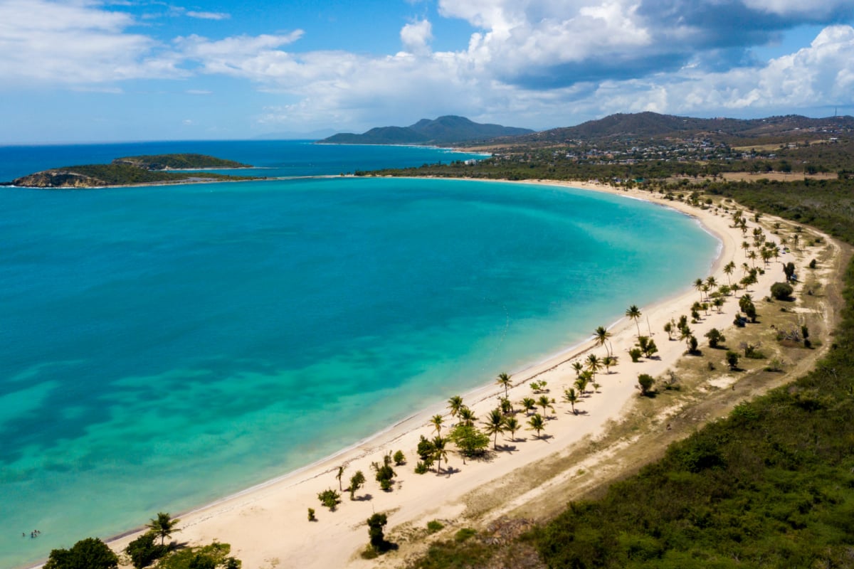 Beautiful Sun Bay beach with small fishing boats and people relaxing in Vieques, Puerto Rico