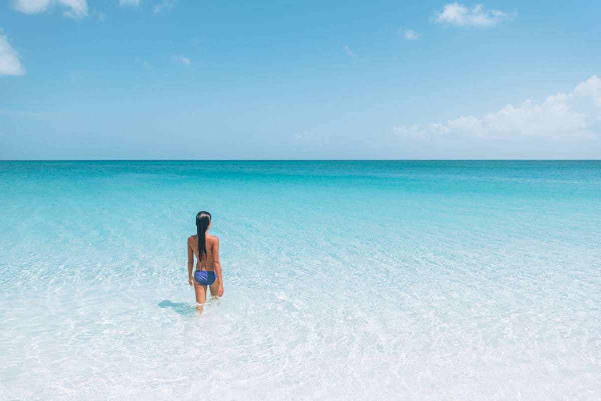 Woman stepping into the ocean in South Caicos, Turks and Caicos