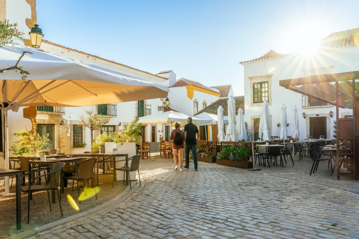 A tourist couple visiting Faro old town street