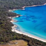 blue waters and white sand of hazards beach as viewed from above