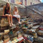 kalyra and savannah sitting on staircase of books