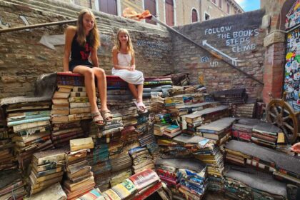 kalyra and savannah sitting on staircase of books