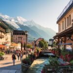 Scenic Chamonix Mont Blanc ski resort town with tourist visiting along Arve river and shops in French Alps