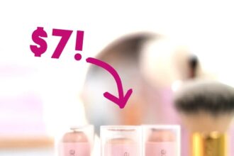 Three tubes of essence Foundation Stick standing on a vanity among brushes and mirrors. Overlaid arrow with label: $7!